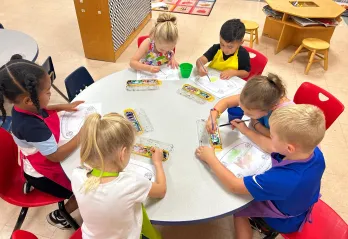 Photo of children at a table doing art projects.