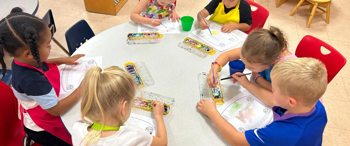 Photo of children at a table doing art projects.