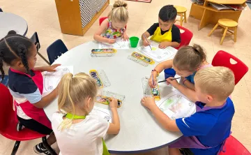 Photo of children at a table doing art projects.
